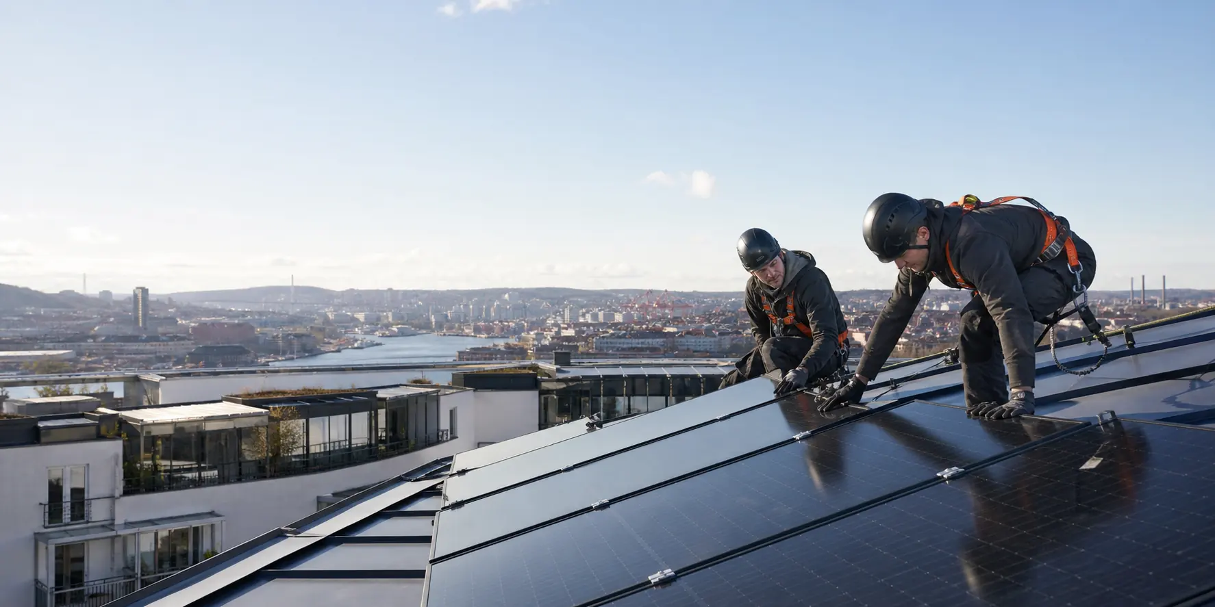 Installatörer monterar solpaneler på ett tak i Göteborg